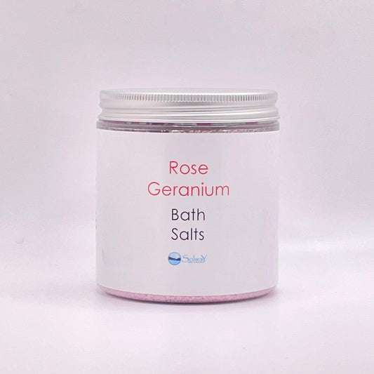 large jar of rose geranium bath salts with silver lid-pink coloured with a white label on white background
