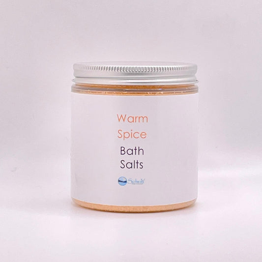 jar of warm spice bath salts-orange colour with white label against white background